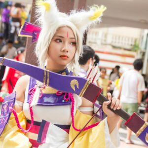 A vibrant cosplay costume showcased by a young adult at an outdoor anime festival, capturing the essence of fun.