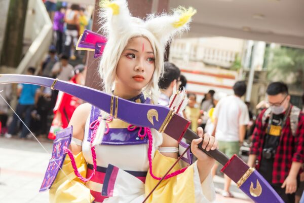 A vibrant cosplay costume showcased by a young adult at an outdoor anime festival, capturing the essence of fun.